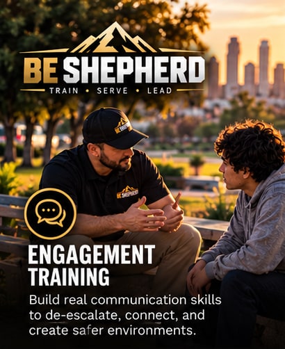 Engagement Training. Build real communication skills to de-escalate, connect, and create safer environments. A Be Shepherd trainer sitting and talking with a young man in a park.